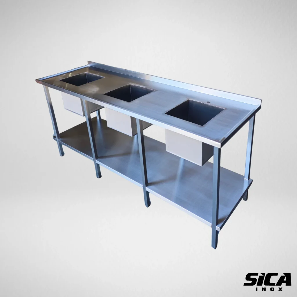 imagem de uma bancada em inox com 3 cubas quadradas em inox com pés tubulares seguindo as normas da vigelancia sanitaria
